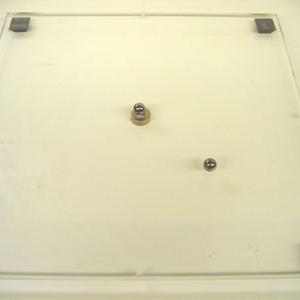 Place the Plexiglas plate with attached ring magnet on the overhead projector.  Roll one of the ball bearings at a grazing angle across the ring magnet.