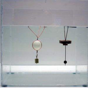 If you press the device into the water and release slowly the surface tension on the circular wire at the top will hold the device under water.  Breaking the surface tension will allow the device to float half way out of the water again.  The surface tension can be broken by adding a drop of soap or by blowing into the circular wire/water surface.
