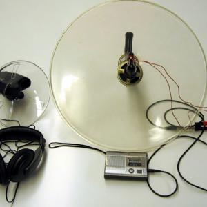 The reflectors can be used in two ways.  The best is to put a speaker at the focal point of a reflector, and pointing in at the reflector.  Use a tape player to play music or speech through the speaker, and "beam" the signal to the students in the audience. The other way to use these is in the original way they were designed.  That is to directionally listen to sound from far away using the parabolic reflector with built in microphone. See 2nd paragraph procedure. 