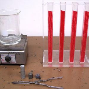Heat the specimens in boiling water for 15 minutes then place in the tracks of the apparatus. The paths can then be measured to determine the specific heat of each of the metals.  