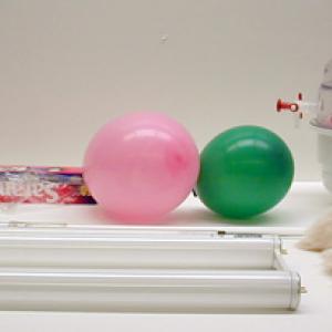 Rub the Fluorescent light with the cats fur in a darkened room.  The light should appear to flash momentarily as it is being rubbed.  Balloons or Saran Wrap can be substituted for the cats fur.