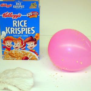 Charge a balloon with the cat's fur.  Wave the balloon over a pile of Rice Krispies or Puffed Wheat and watch the breakfast food jump onto the balloon. 