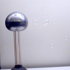 Turn on the Van de Graaff and blow soap bubbles at it.  Initially the bubbles will be attracted to the Van de Graaff until the first bubble touches the Van de Graaff and breaks.  At that point the rest of the bubbles will stop, turn around, and travel away from the Van de Graaff.