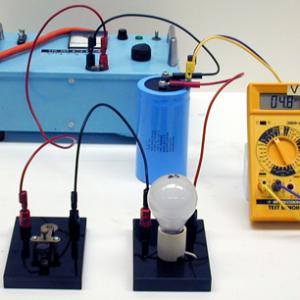 Hook the power supply, capacitor, light bulb, and Key switch in series as a circuit. Observe the voltages with and without the capacitor in the circuit. 