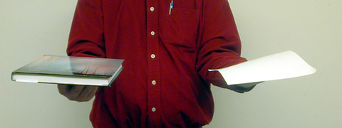 person holding a book and a sheet of paper