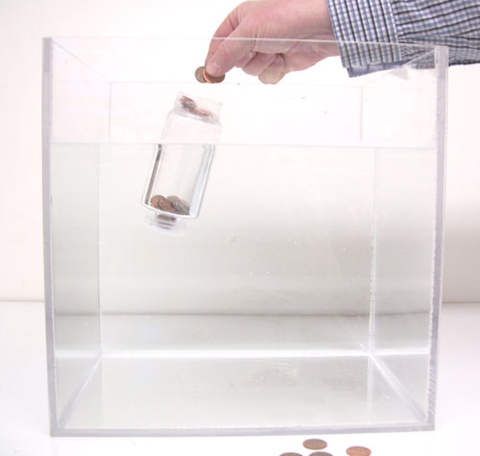 person dropping pennies into a bottle with attached ring, water tank
